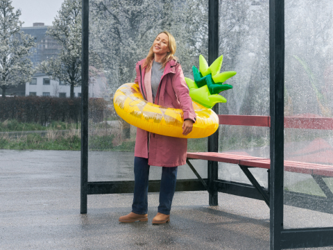 a person carrying a large yellow pineapple lilo on a rainy day