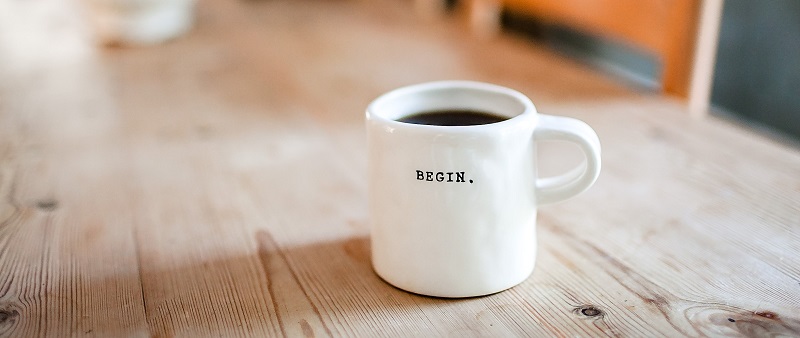 Cup of coffee without milk on a long wooden table