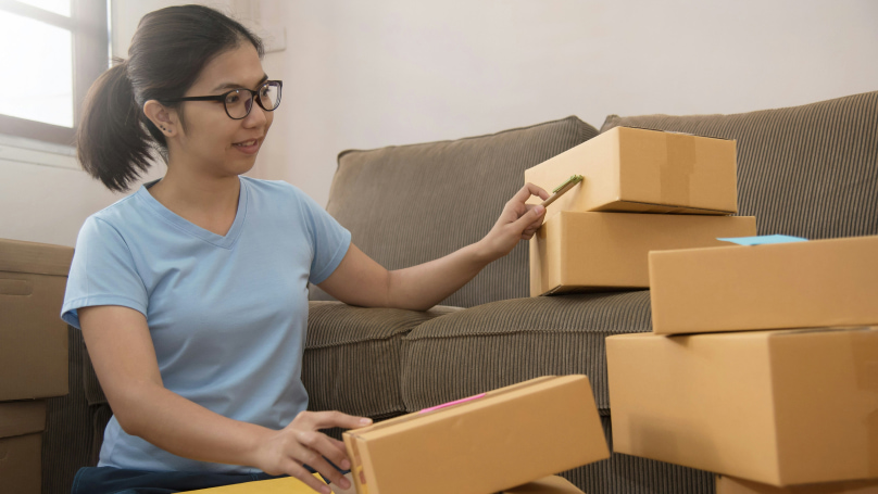 A person packing parcels in cardboard boxes