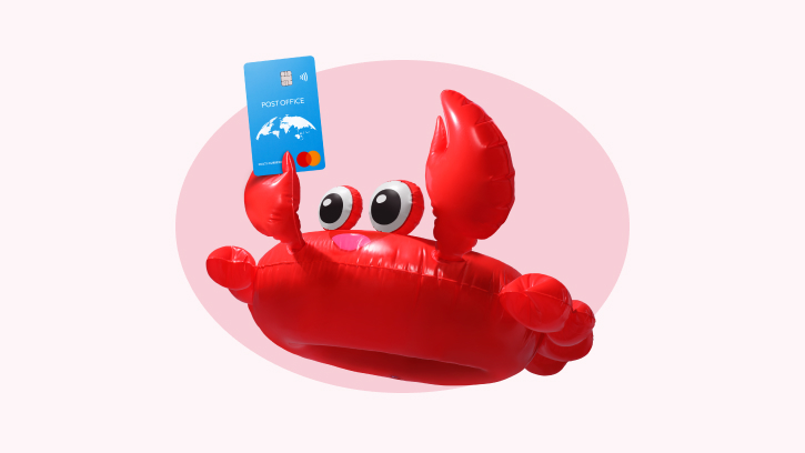 a giant red crab lilo holding a Post Office travel money card aloft