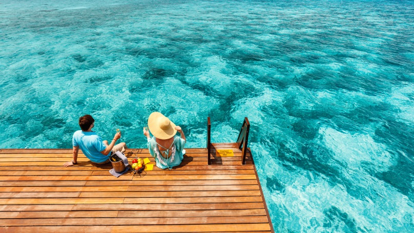 a couple relaxing by the sea with a picnic