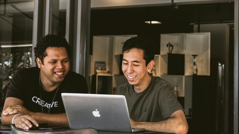 Two individuals engaged in a collaborative work session at a table.