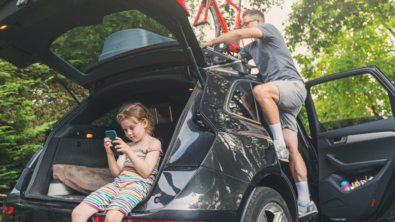 father and daughter packing things in their car for a trip