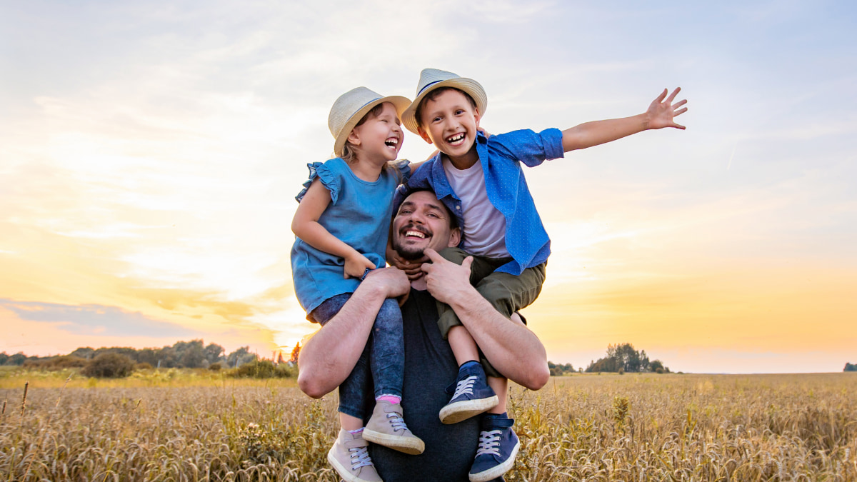 a father holding his two kids in the air