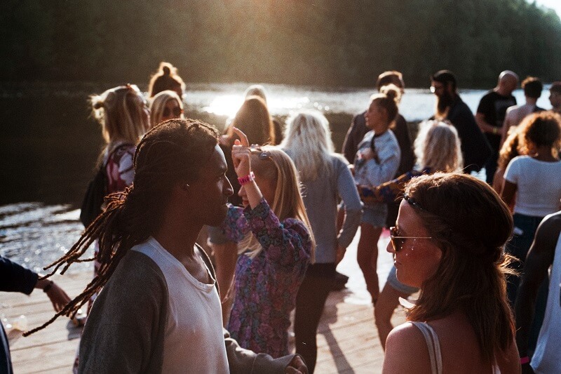 Young men and women dancing in sunny location