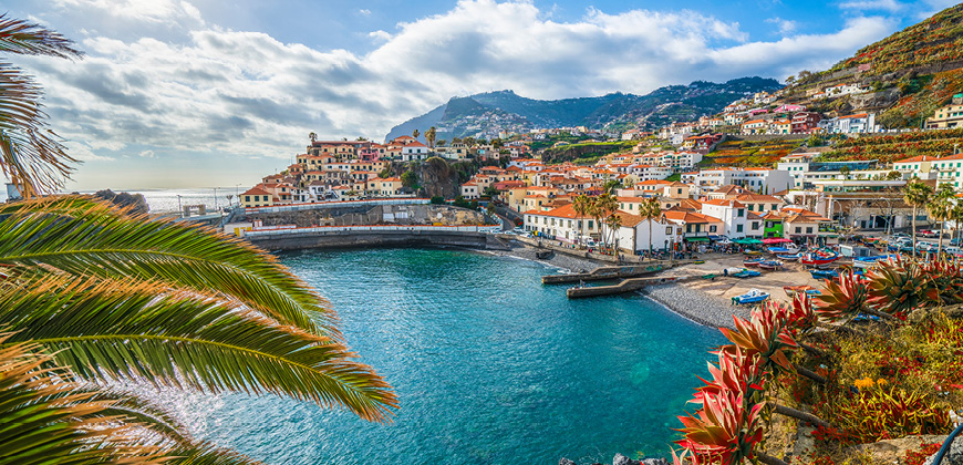 A view of houses near the coast, against a blues sky